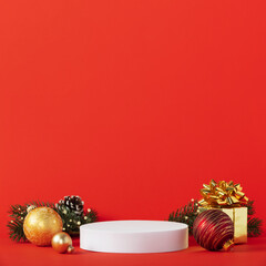 White podium and christmas decorations on red background.