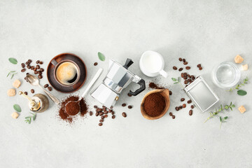 Obraz na płótnie Canvas Moka pot, espresso cup, ground coffee, milk, sugar and coffee beans on a grey concrete background