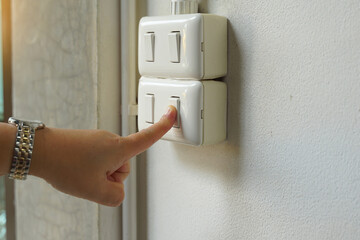 Turn off the lights before leaving the office. Concept to conserve energy and the environment, reduce global warming, save energy. Soft and selective focus.