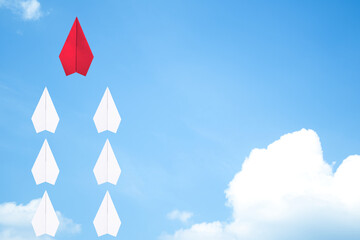 Red paper plane flying leads white paper planes on the sky. The leadership idea for working...