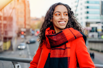Facial close-up portrait of young attractive smiling female walking down streets of the city and...