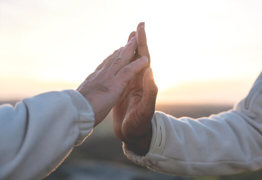 Hands of white man and black african american man gently and softly touching each other at sunset. Concept of fighting with racism and friendship between people toned image