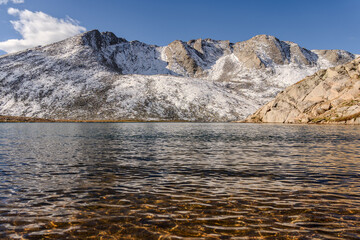 Snow covered mountain, water, and tundra at Summit Lake at Mount Evans/Mount Blue Sky near Idaho Springs, Colorado, on a sunny fall/winter day