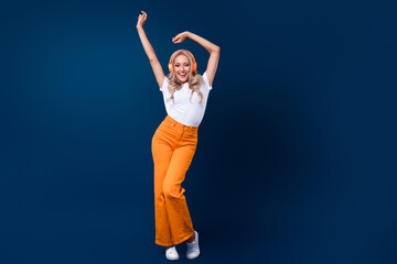 Full length photo of cheerful glad girl listening soundtrack dancing like wednesday addams empty space isolated on blue color background - Powered by Adobe