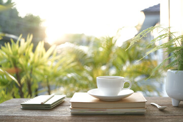 White coffee cup and diary notebooks and plant pot chill outdoor drinking
