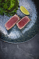 Grilled tuna pieces with fresh salad and a slice of lemon. Restaurant food service, banquet, buffet