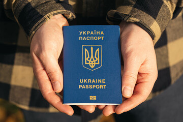 Passport of a citizen of Ukraine in male hands, close-up, migration concept.