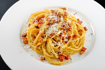 Plate of spaghetti carbonara with black pepper and pecorino cheese