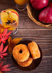 Sweet homemade apple cider donuts with cinnamon sugar on the wooden table. Autumn food.