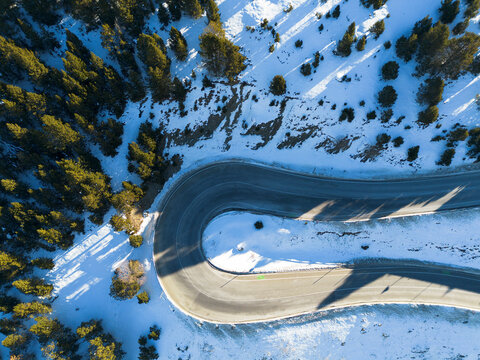 Aerial photo of a snowy Andorran mountain road winding through winter landscapes.