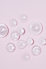 Glycerin gel texture. Transparent serum drop on pink background. Liquid gel moisturizer with bubbles macro