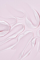 Liquid gel cosmetic smudge drops texture on bpink background. cosmetic smears cream texture. skin care product stroke flat lay, cream with hyaluronic acid