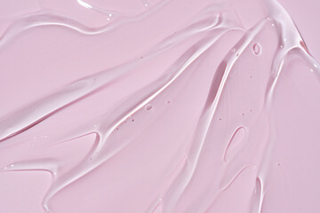 Texture of face serum. Abstract background of moisturizing transparent gel on pink background