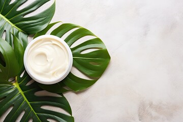Top view of monstera tropical plant leaves on a marble background, showcasing natural organic cosmetic products. Promotes skin care and beauty treatment. - obrazy, fototapety, plakaty
