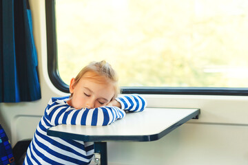 Little child sleeping in a train. Travel, traveling with small children. Cute boy is traveling on the train.
