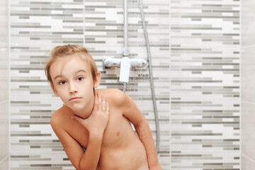 Boy washing himself in shower. Healthy childhood, lifestyle concept.