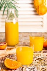 Fresh orange juice on table with slices fruits.