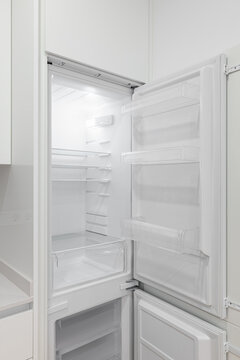 Photo of a white refrigerator with doors open in a modern kitchen