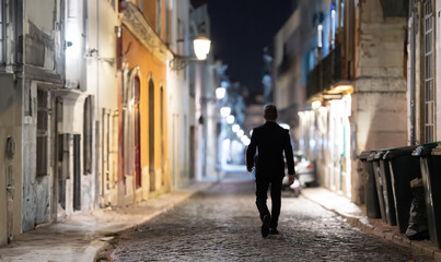 A person walking through the empty night street