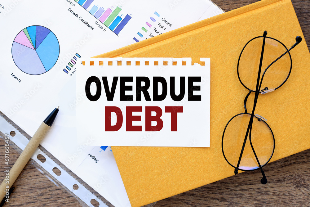 Poster overdue debt text on the page on a yellow notepad.