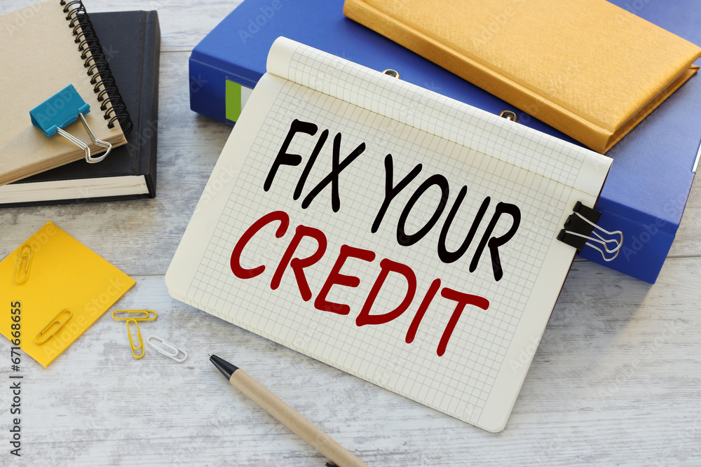 Poster fix your credit text on a notepad near a blue folder with a yellow notepad