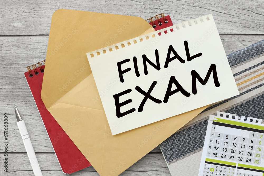 Poster sheet of paper on an envelope on a red notepad. calendar. text final exam