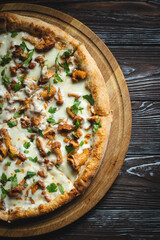 Freshly baked pizza with mushrooms on a dark background.