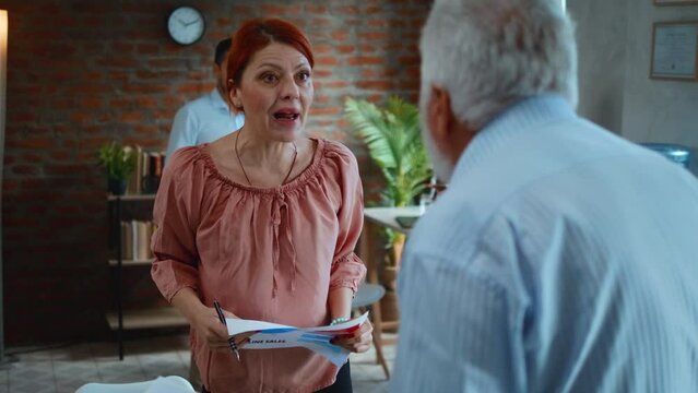 Annoyed businesswoman argues with elderly man in office, angry senior boss shouting on female worker, mistakes and problem at work