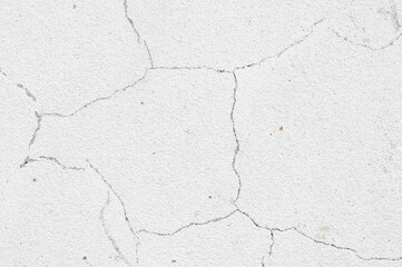 An old white wall with a cracked texture is decorated with cement mortar