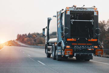Garbage Truck In Motion On a European Highway. Waste Distribution And Utilization Policy Concept. Process of waste recycling - obrazy, fototapety, plakaty