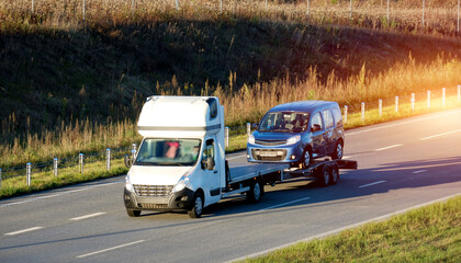 A side view of the tow truck with a damaged commercial vehicle after being in a traffic accident....