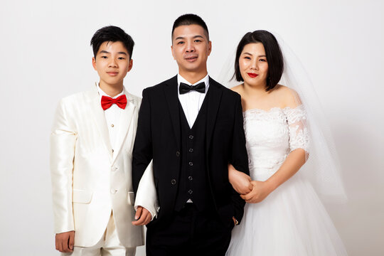 Group photo of a family of three wearing formal wedding attire