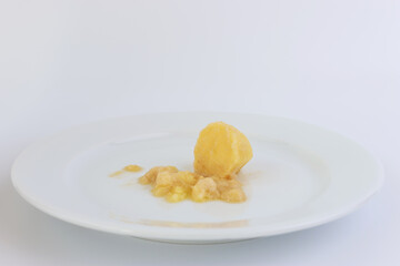 A miniature grater and grated potatoes on a white plate.