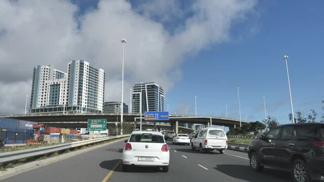 Trucks, cars and motorbikes head into city in slow traffic on motorway