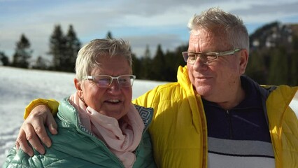 Happy senior couple having tender moment during trekking day in the mountains - Winter vacation and pensioners concept - Powered by Adobe