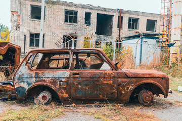 On the side of the road is a wrecked, burned-out civilian car. War in Ukraine