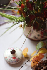 Bouquet of autumn flowers in a teapot as a vase on a table
