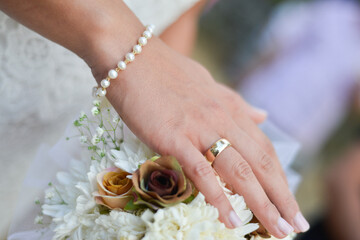 Gold ring on a ginger .Wedding bouquet of flowers in brides' hands. - 671696251