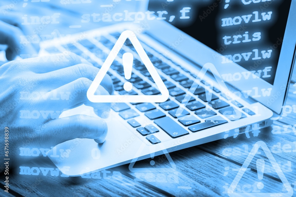 Aufkleber cyber security. man works on computer with alert sign