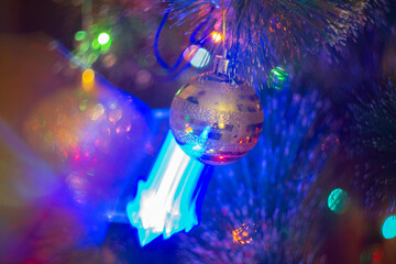 Christmas decorations and colored lights garlands on Christmas tree. Bright lights and highlights...