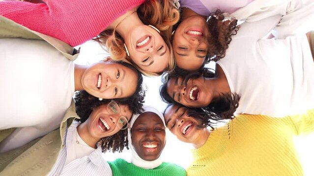 Multiracial group of young women in circle smiling together at camera - Happy female friends having fun taking video selfie outdoors - Friendship and diversity concept