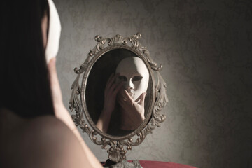woman in front of the mirror takes off her mask, abstract concept