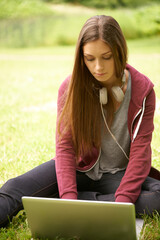 Woman in park with laptop to study for university, internet connection and website for school project. Relax, computer and college student on grass in campus garden for research, technology and peace