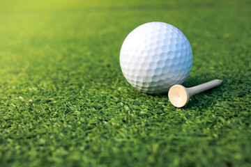 Golf balls and tees are placed on artificial grass.