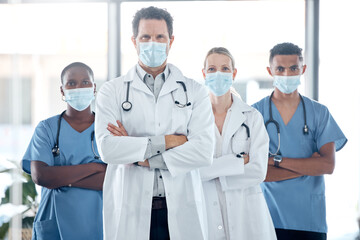 Doctor, nurse and leadership, covid with face mask for team safety with arms crossed in a medical...