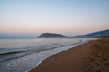 Beautiful sunrise scene on Alanya beach with view to famous Alanya island, in Turkey