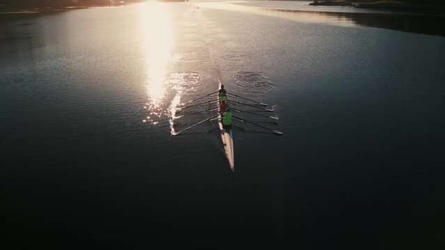 Aerial view of a crew of athletes rowing a boat at sunrise. Halifax, Canada