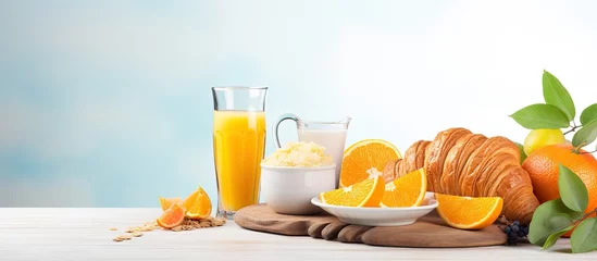 Tuinposter Assorted set of nutritious morning meal Includes orange juice granola croissant coffee and fresh fruit © AkuAku