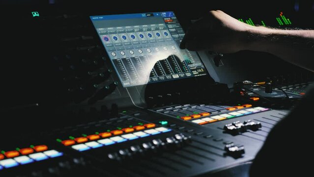 The mixing console controls the sound. The sound engineer changes the volume and other parameters by pressing his finger on the touch screen. Modern sound equipment. Recording studio. Close-up