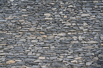 Die Steinmauer an einer Hauswand von Handarbeit errichtet